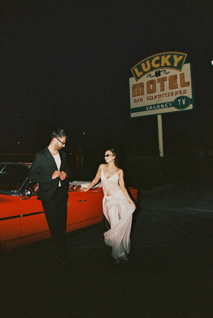 Couples film elopement photos with a red convertible in Las Vegas