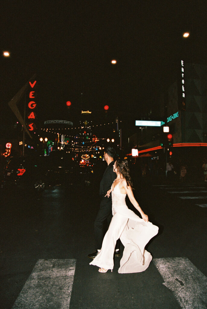 Couple walking across the street for their film Vegas elopement shoot