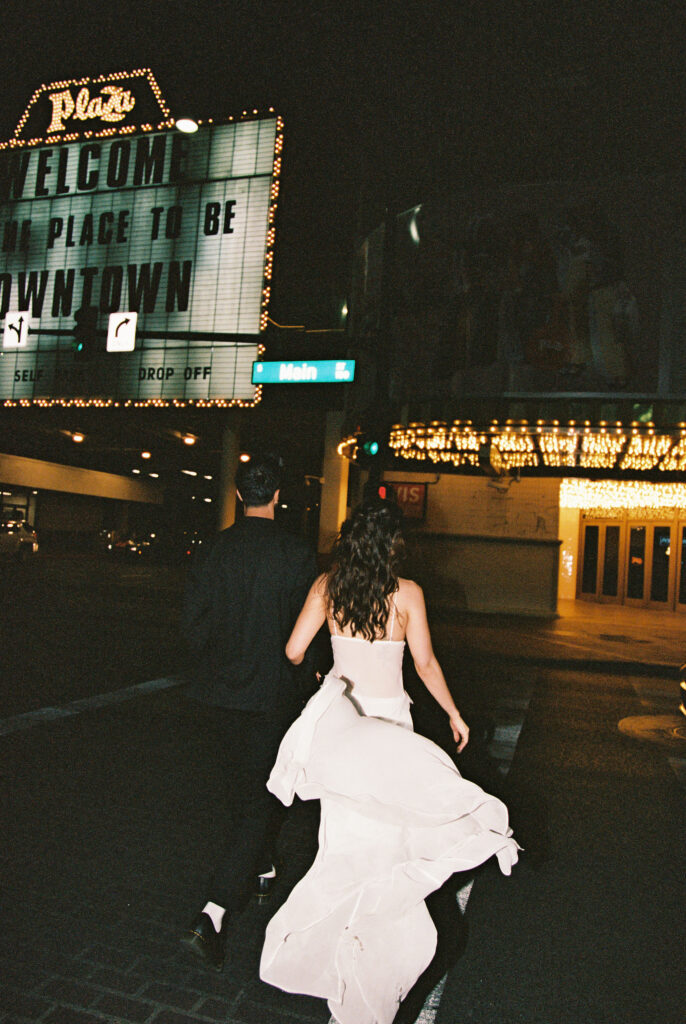 Couple walking across the street for their film Vegas elopement shoot