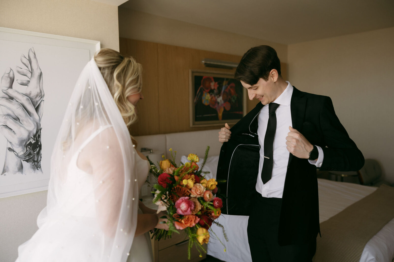 Groom showing off his suit to the bride during their first look
