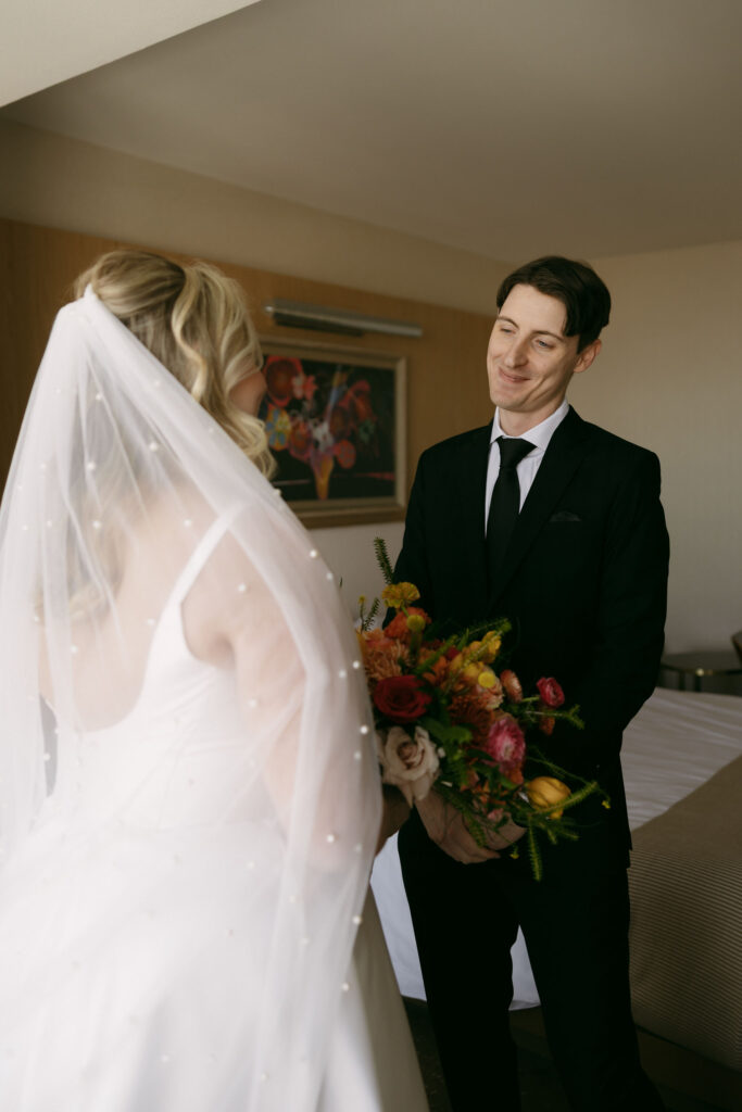 Bride and groom smiling at each other during their first look