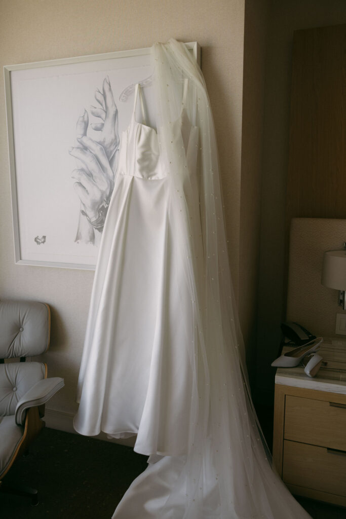 Bride wedding dress hanging in her hotel room