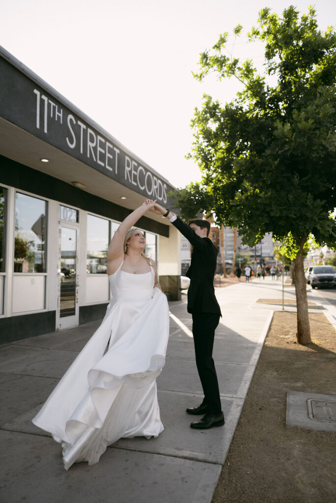 Bride and groom dancing downtown