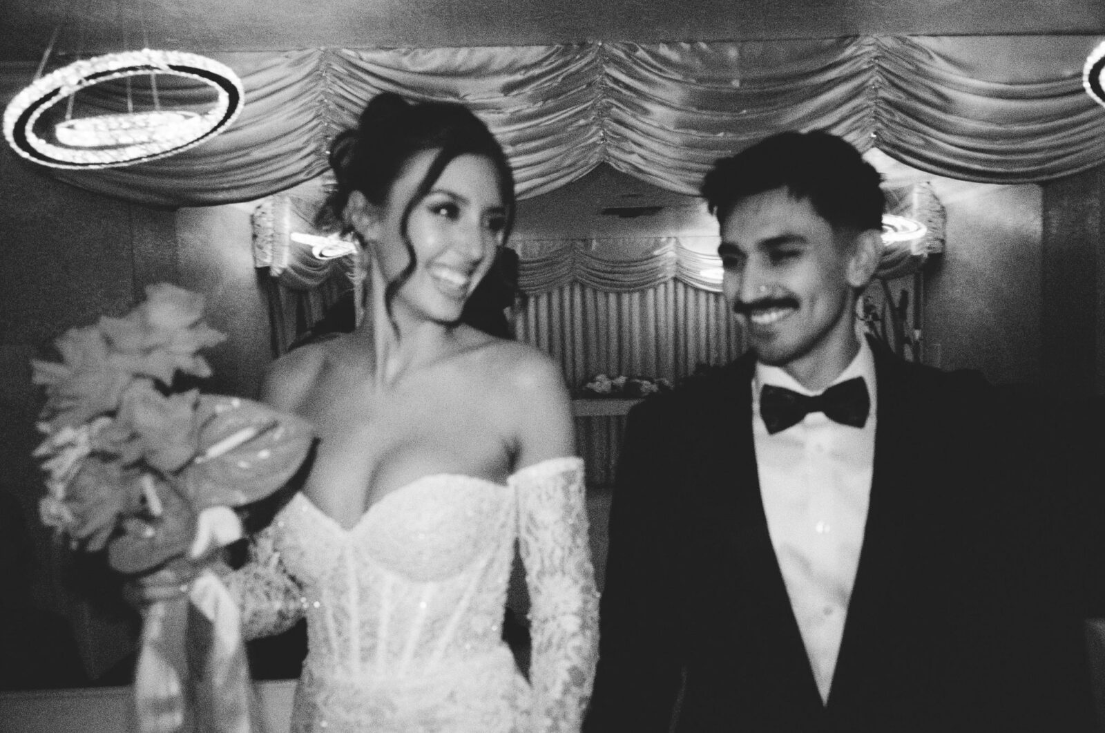 Black and white photo of a bride and groom walking back down the aisle after their Little White Chapel elopement on film