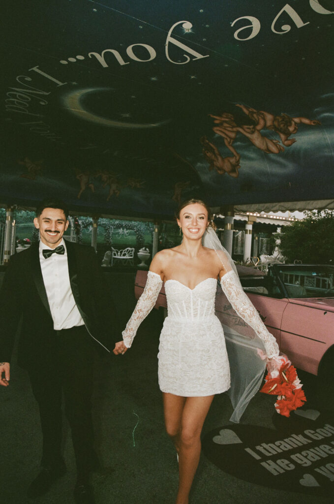 Bride and groom walking through The Tunnel of Love at The Little White Wedding Chapel
