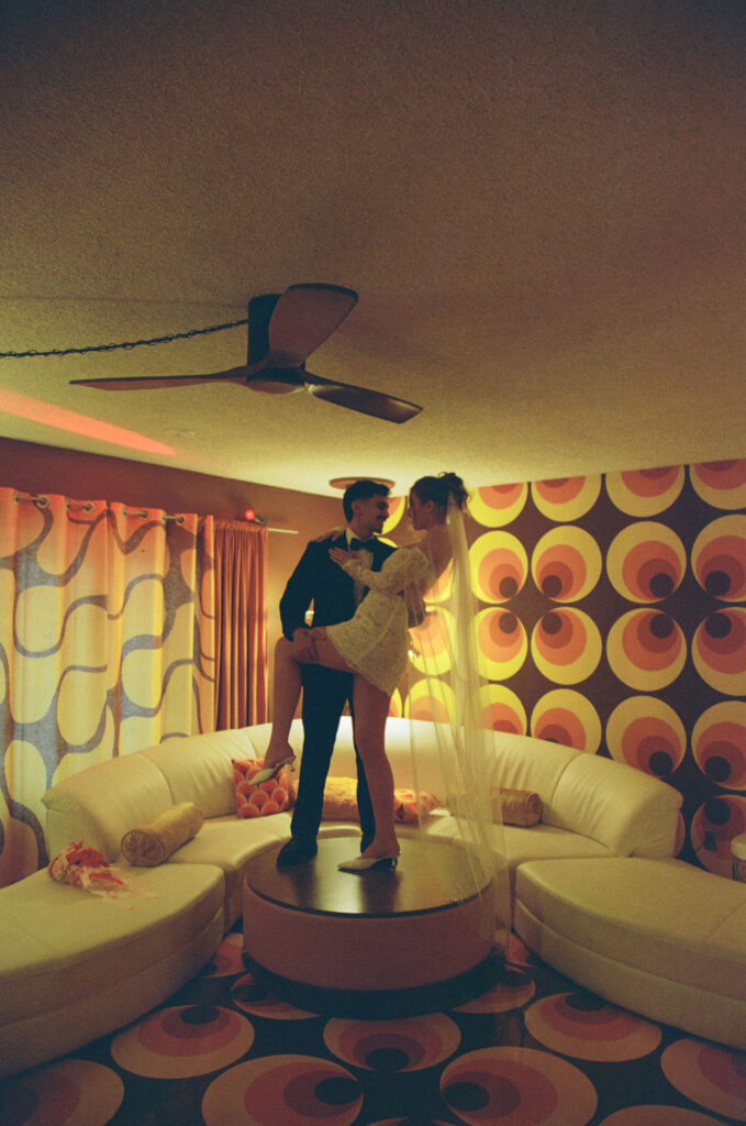 Bride and groom dancing together in the living room of a vintage 70s Vegas home, captured on film.