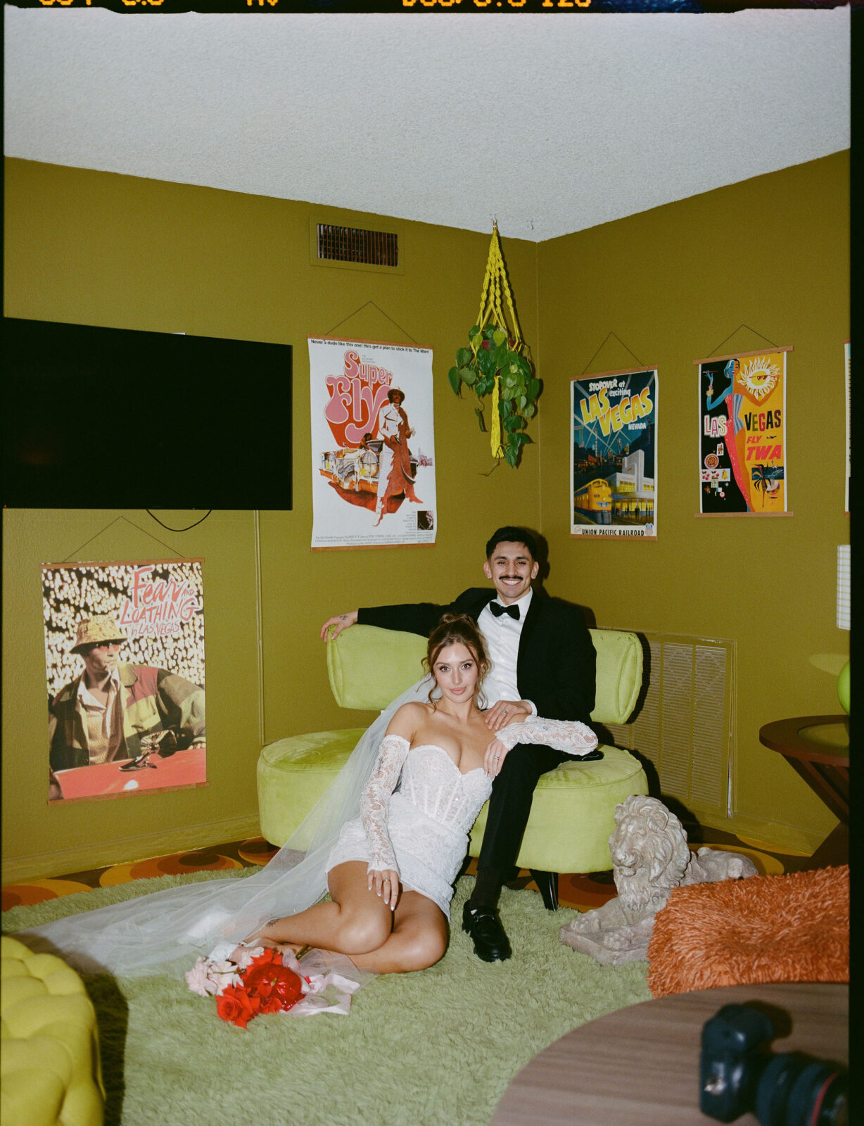 Film photo of a bride and groom posing in a vintage 70's inspired house