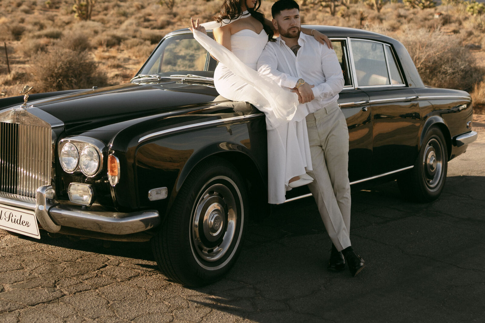 Close up shot of a couple posing with a classic Rolls Royce for their Las Vegas engagement photos in Red Rock Canyon