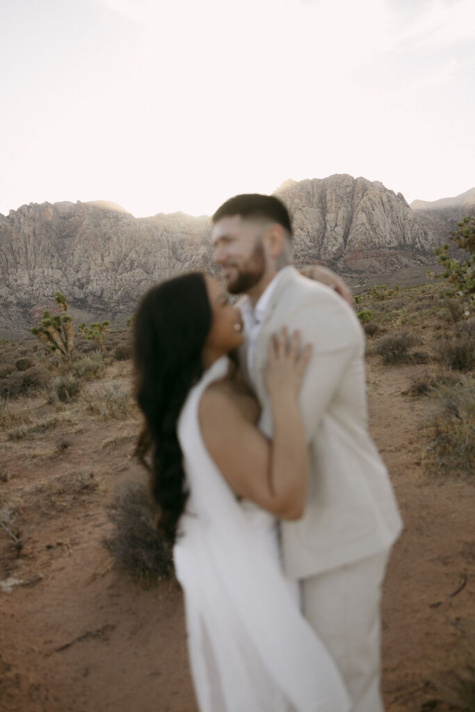 Blurry, artistic photo of the couple laughing together in the Las Vegas desert.
