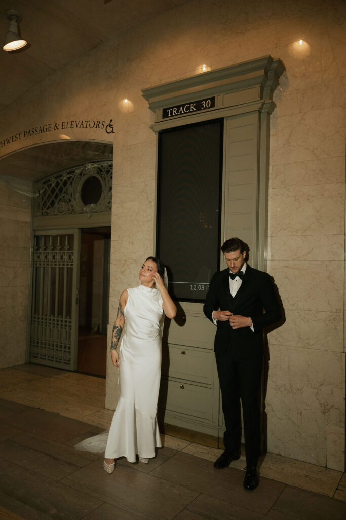 Flash wedding photo of a bride and groom posing at Grand Central Station.