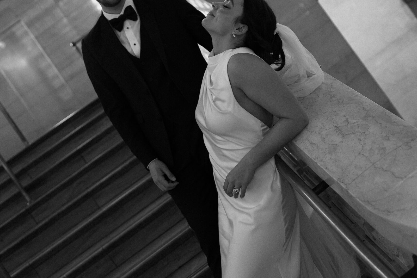 Close up black and white photo of a couple posing on the East Balcony at Grand Central Station during their New York City elopement.