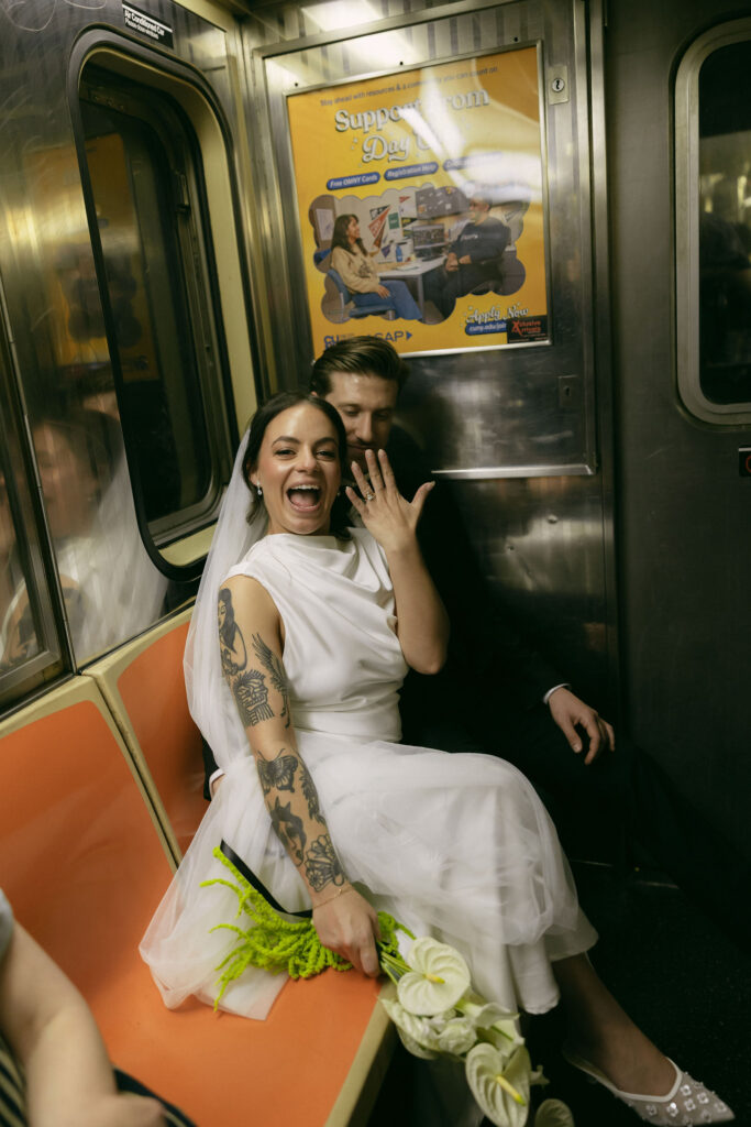 Bride showing her ring while sitting on the subway after a New York City Hall elopement.
