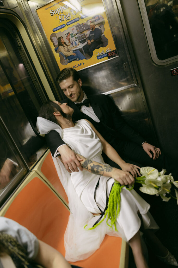 New York City Hall elopement couple cuddled together inside a subway car with wedding attire.