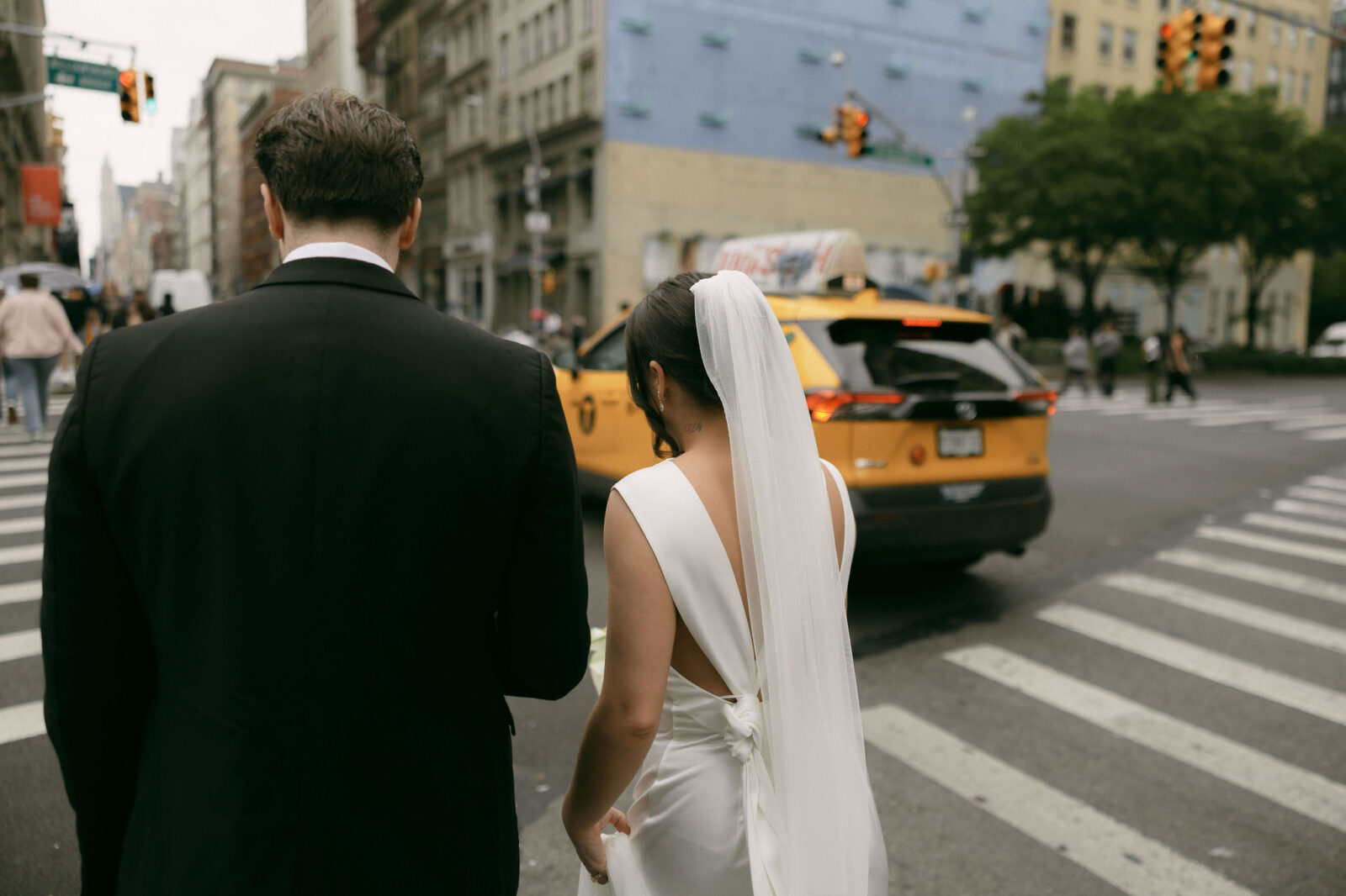 Wide shot of a bride and groom walking in NYC.