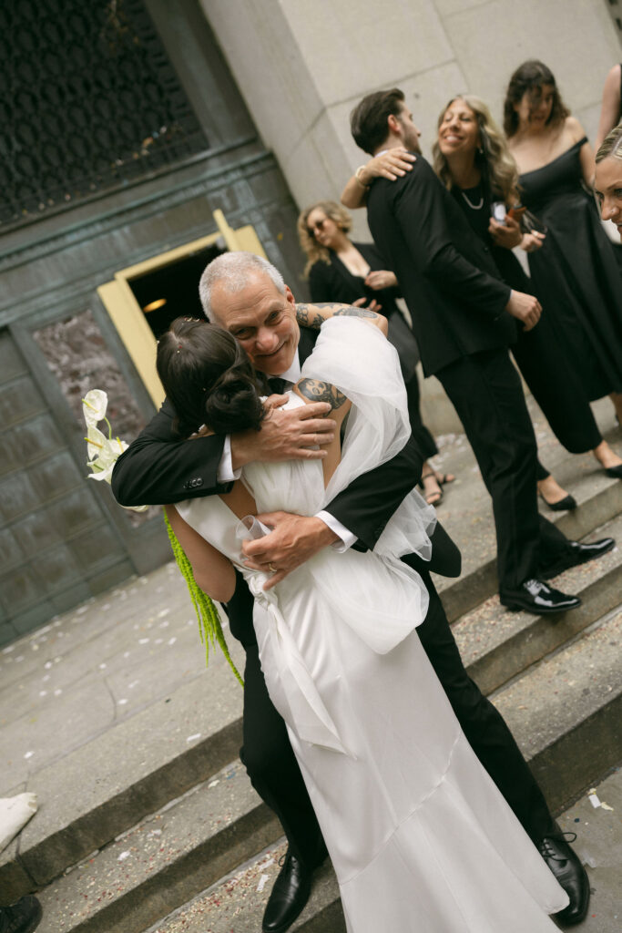 Bride hugging a family member outside City Hall following a New York City Hall elopement ceremony.
