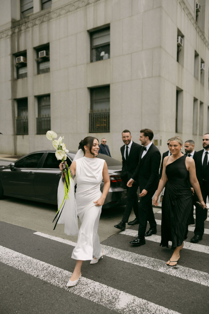 Bride walking through New York City with wedding guests after a New York City Hall elopement.