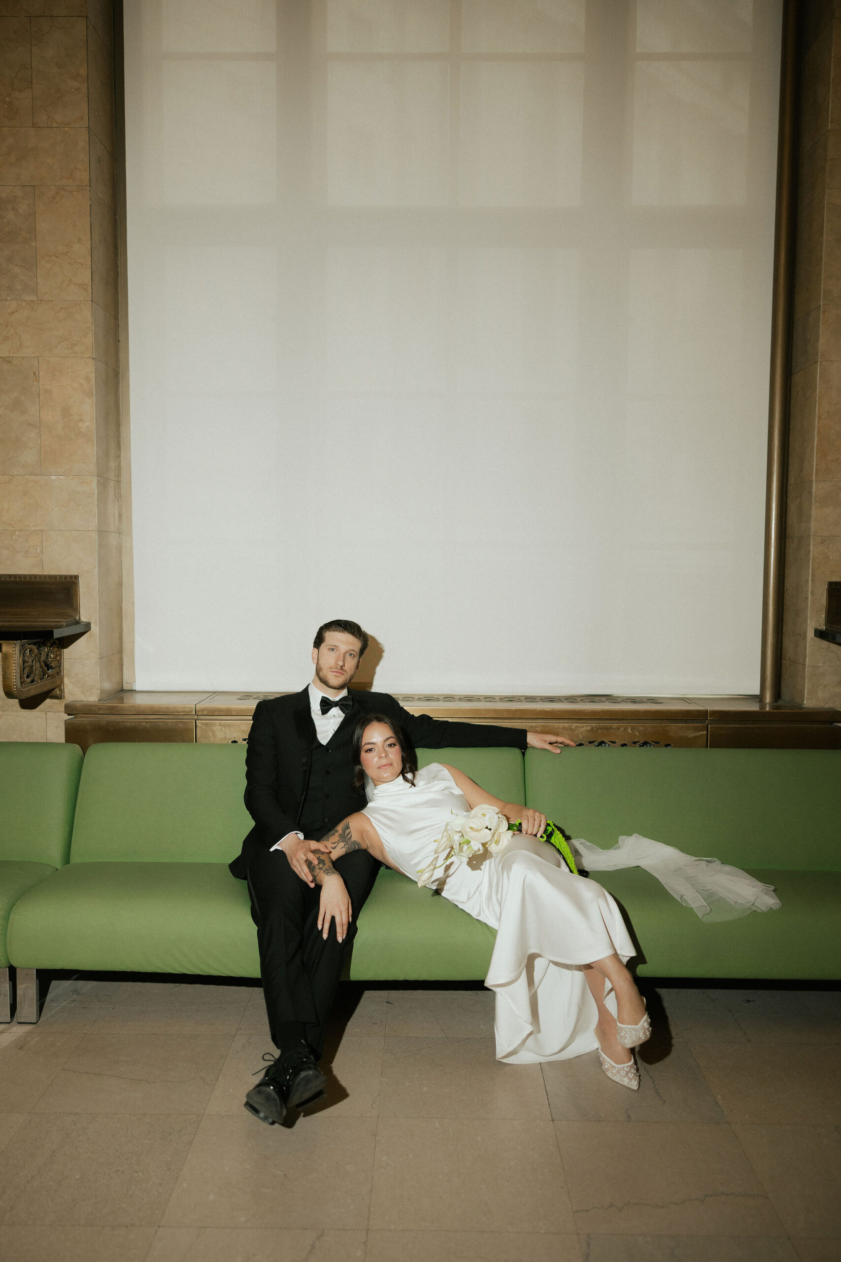 Bride and groom posing at New York City Hall for their elopement photos.