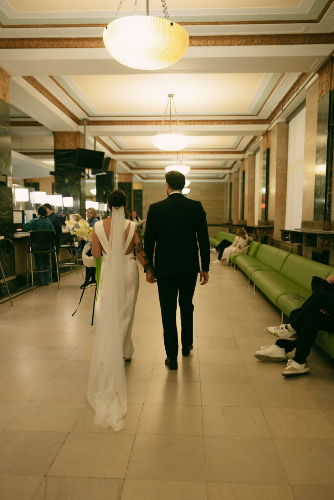 Bride and groom walking through the NYC City Clerk at 141 Worth Street.