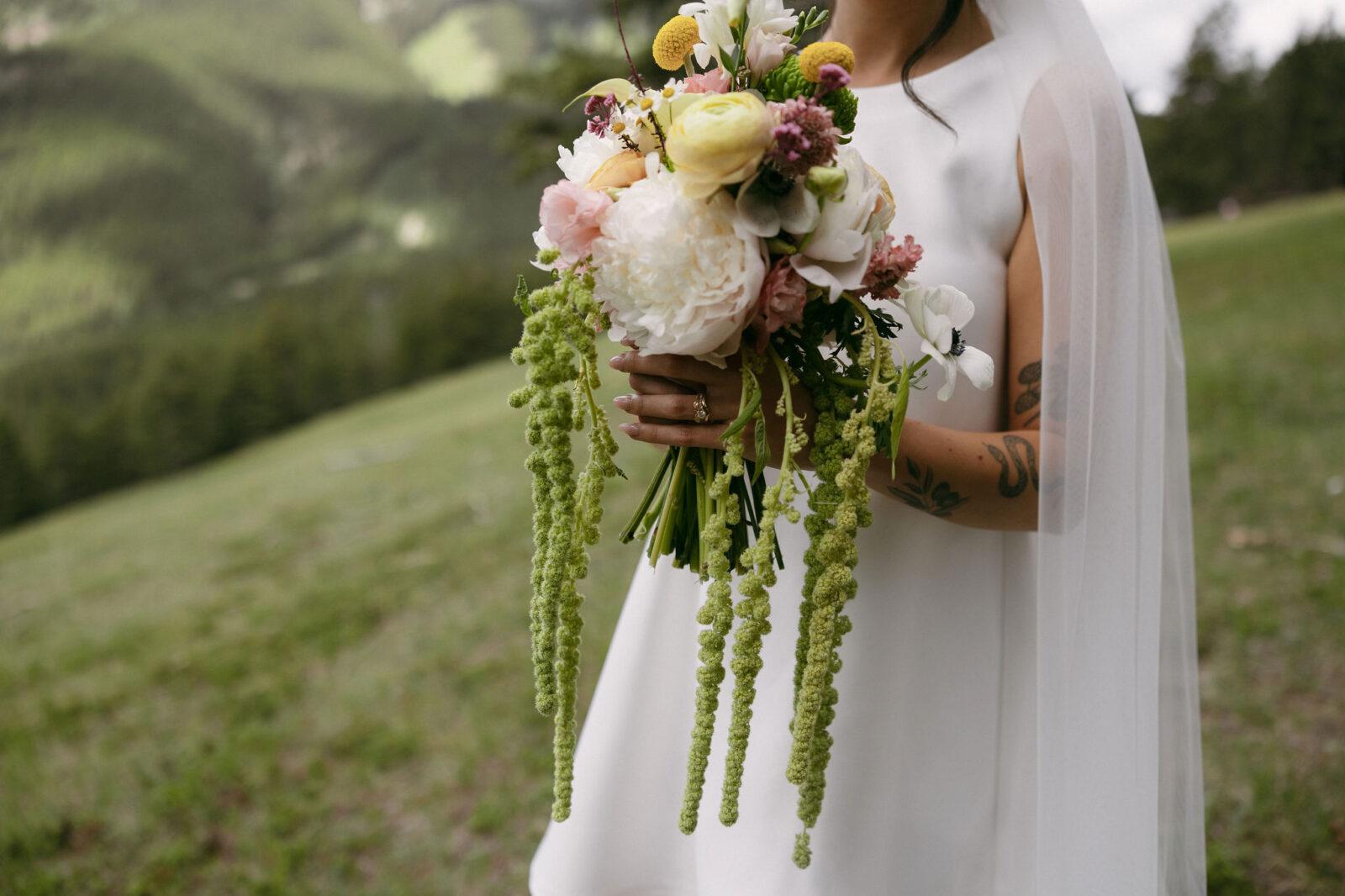 Wide shot of a bride holding her Banff National Park elopement bouquet.