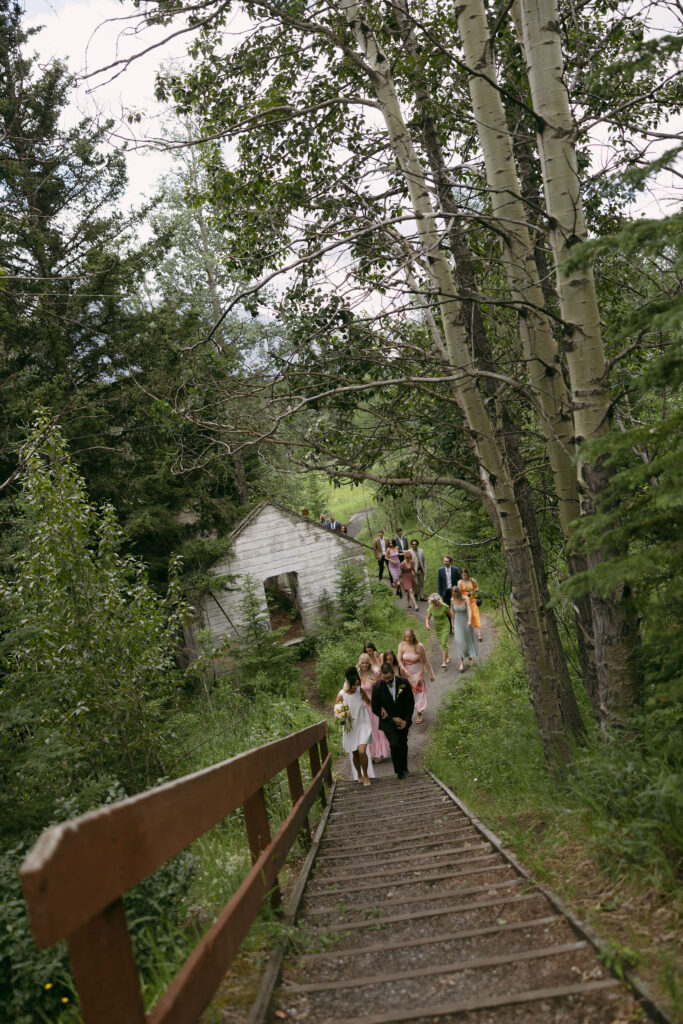 Bride and their guests walking up stairs in Banff National Park.