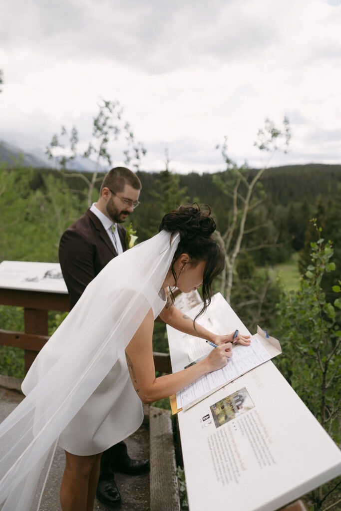 Bride and groom signing their marriage license in Banff National Park