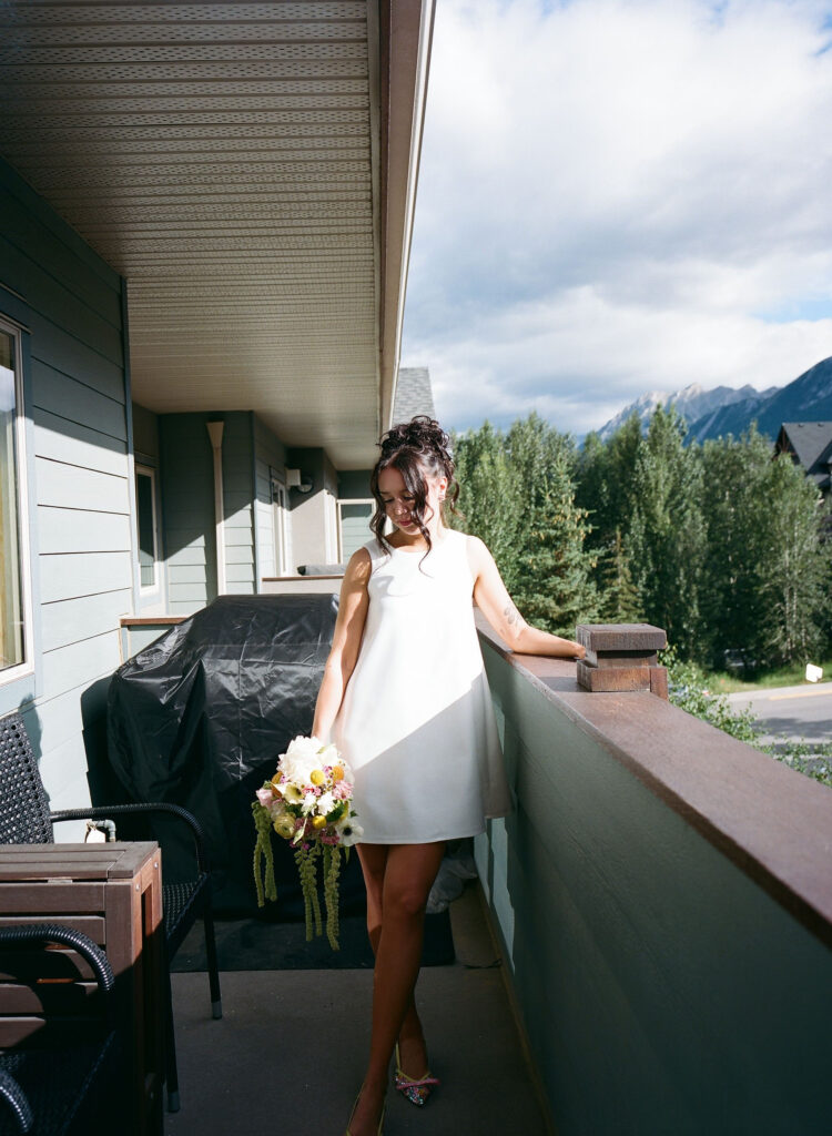 Film photo of a bride posing in Banff National Park at a cabin.
